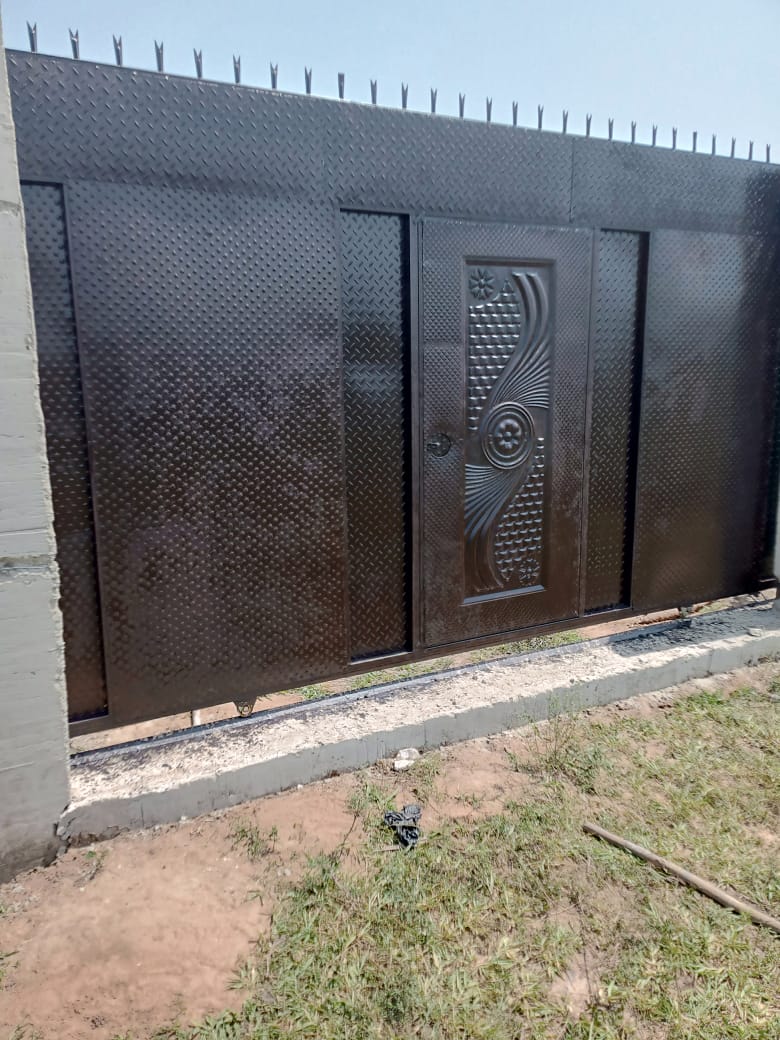 Completed metal security gate at a community project site